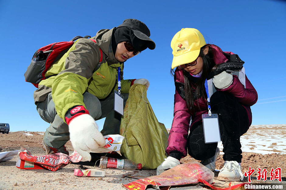 10月16日，两名环保志愿者在清点捡拾到得垃圾。16日至18日，由中华环保基金会主办的首次青藏线垃圾清理调查公益活动在海拔4767米的昆仑山口至海拔5231米唐古拉山口的450公里范围内，对青藏公路沿线垃圾进行了详细清理和调查。